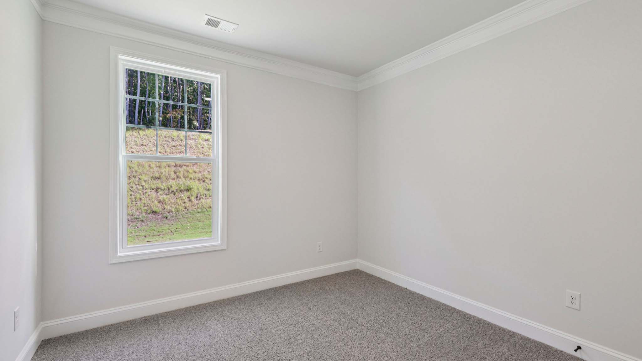 Carpeted bedroom with small window