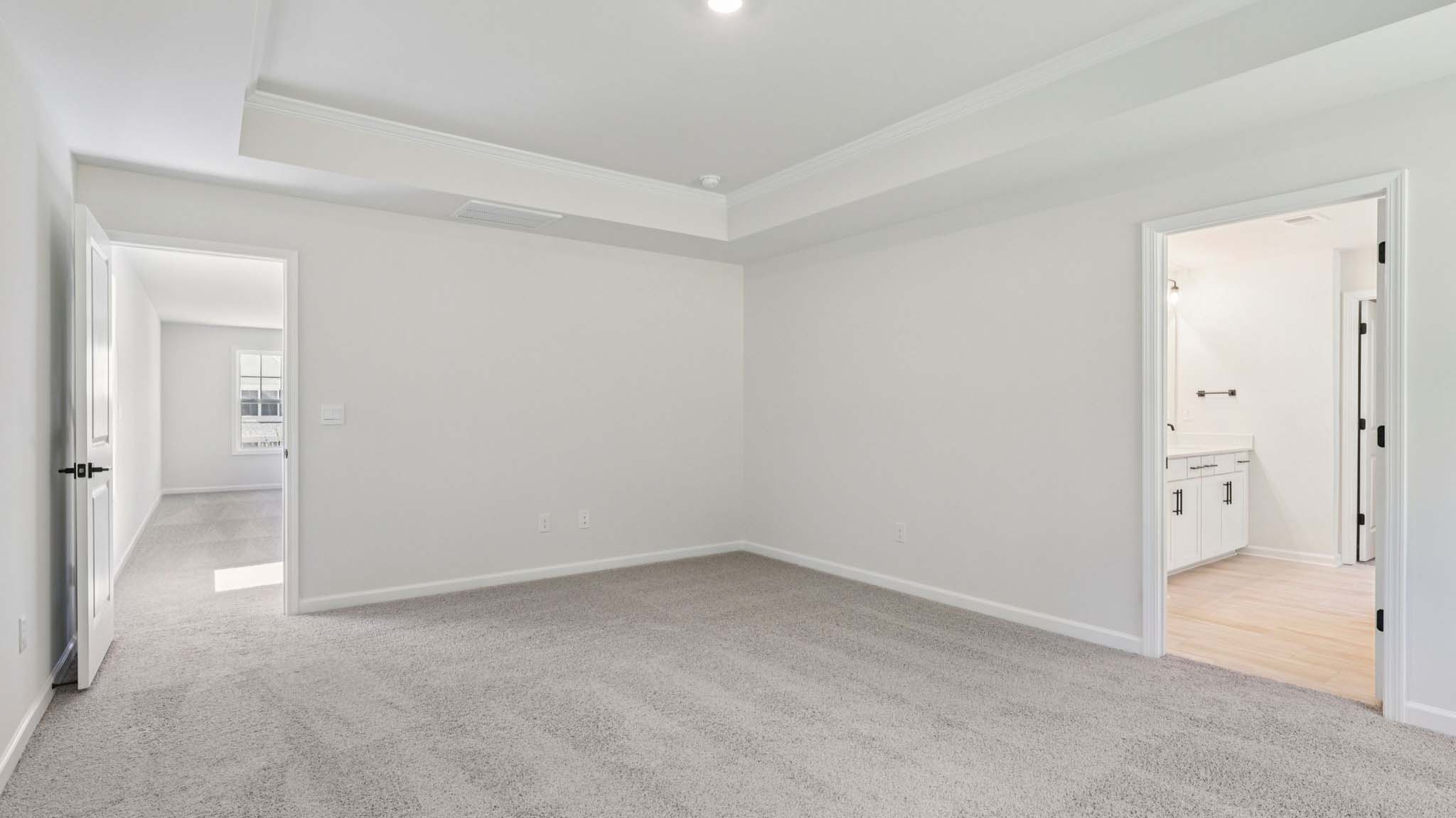 Primary bedroom with carpet and large windows