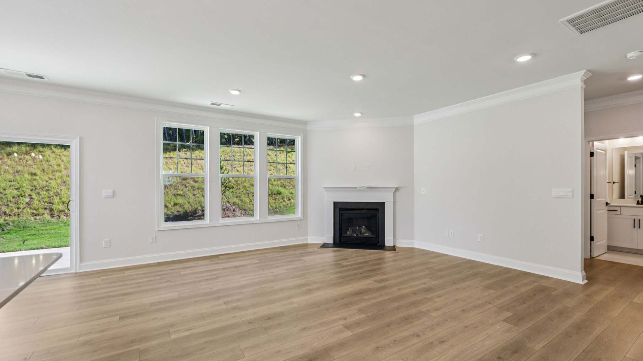 open concept living room with fireplace and view of kitchen, breakfast area and staircase