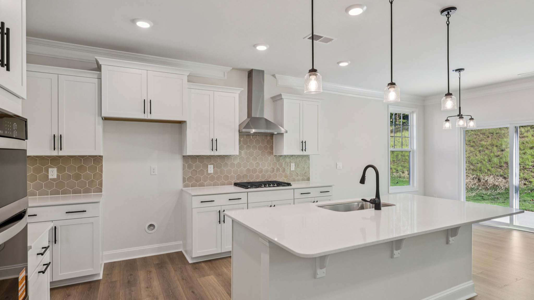 open concept kitchen and island with white cabinets and stainless steel appliances
