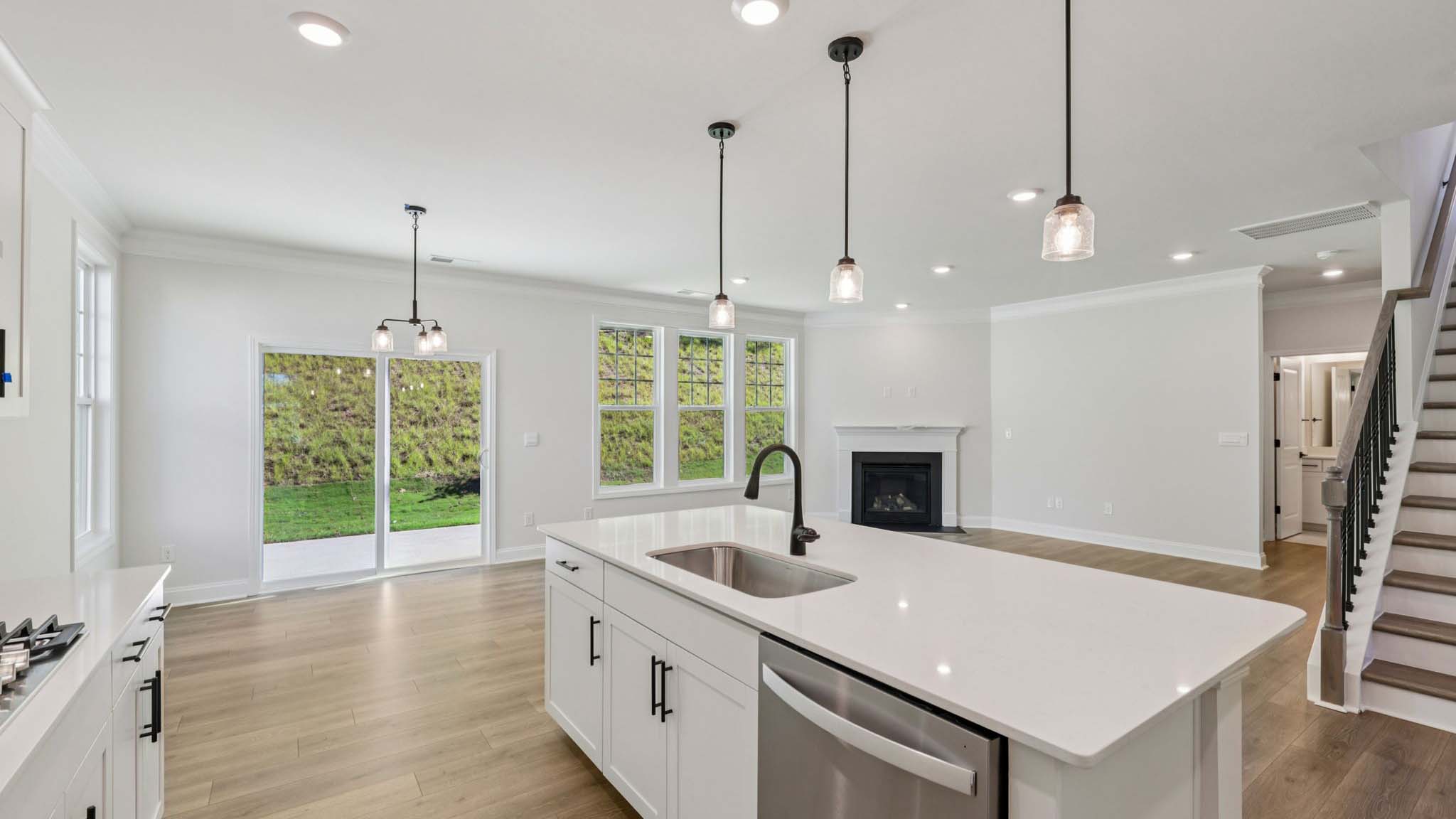 open concept kitchen and island with white cabinets and stainless steel appliances
