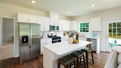 Adair Woods Winston model kitchen and island with Quartz countertop, white cabinets and stainless steel appliances