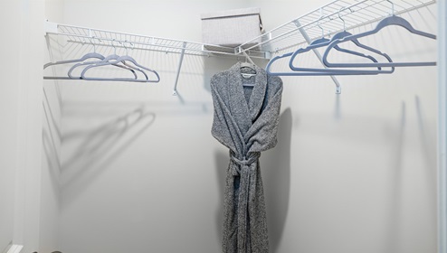 Adair Woods Winston model carpeted walk in closet with built in hanging racks