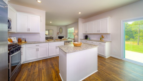 Kitchen and island with white cabinets and stainless steel appliances