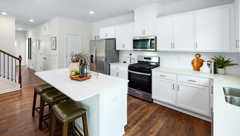 Adair Woods Winston model kitchen and island with Quartz countertop, white cabinets and stainless steel appliances