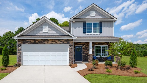 Adair Woods Winston Two-story model home with grey siding and stone and a two car garage