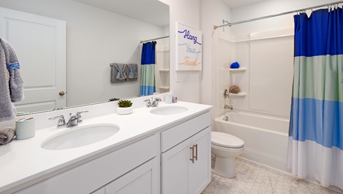 Bathroom with bathtub and shower combination, and white cabinets