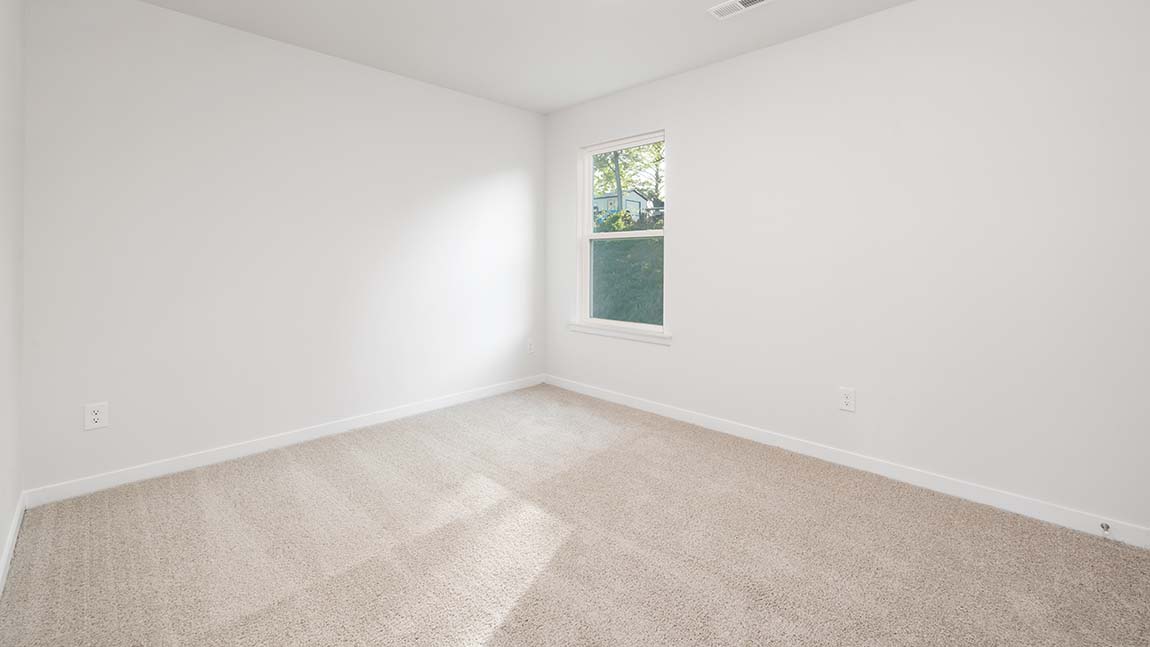 Carpeted bedroom with large window