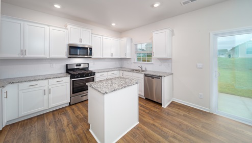 Kitchen and island, white cabinets and wood flooring