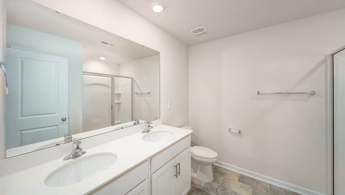 Primary bathroom with double sinks, white counters and cabinets