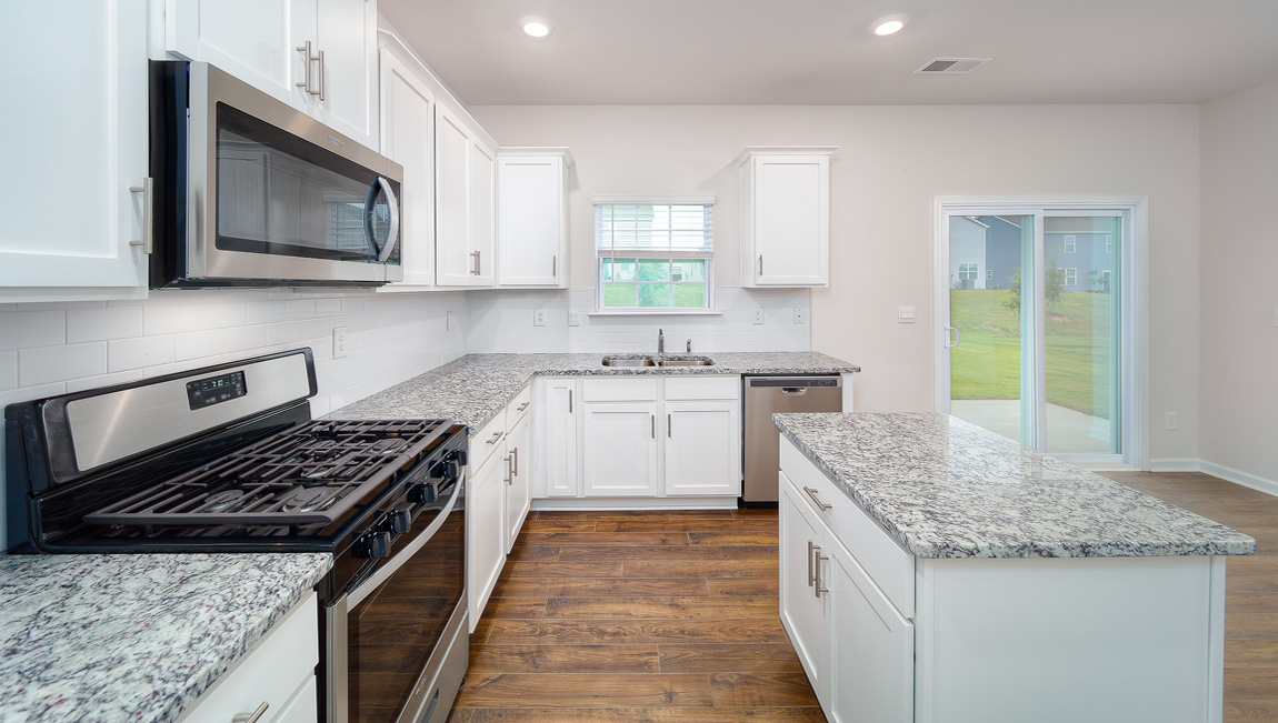 Kitchen and island, white cabinets and wood flooring