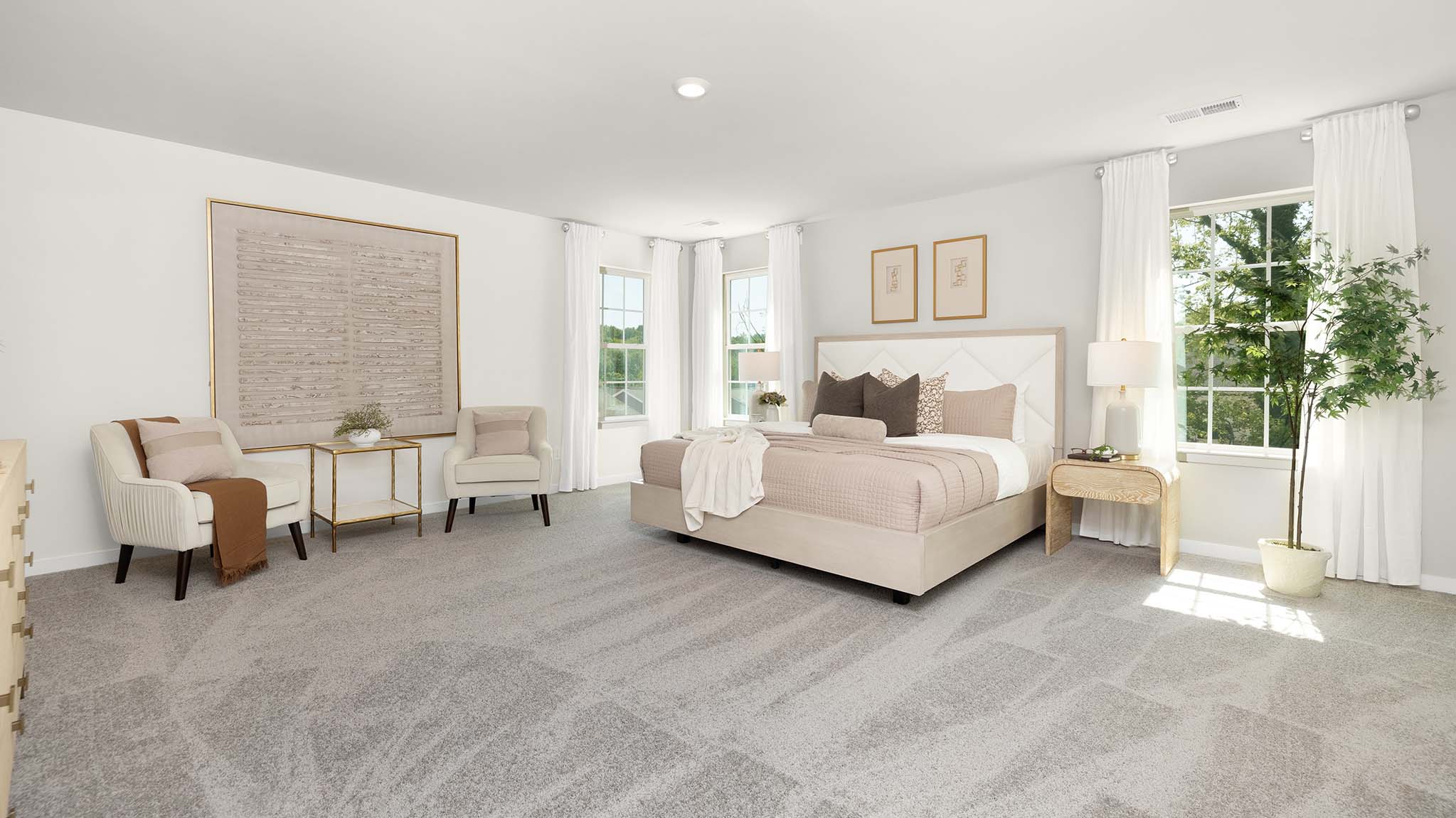 Primary carpeted bedroom with large windows