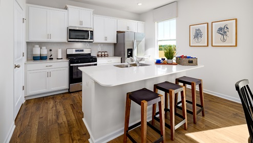 Kitchen with island, white cabinets, vinyl floors, and stainless steel appliances