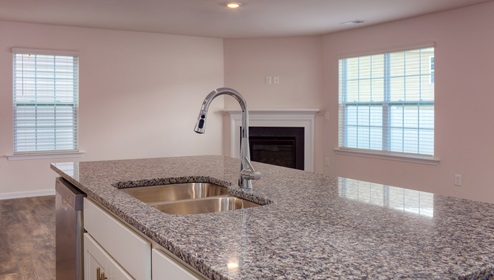 Kitchen and island, white cabinets, wood floors, and stainless steel appliances