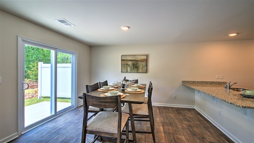 Dining area beside kitchen with sliding glass doors outside
