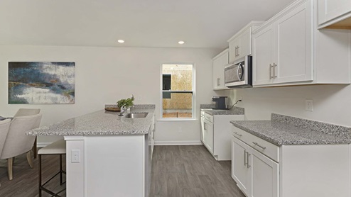 Kitchen and island with white cabinets, granite countertops, vinyl floors and stainless steel appliances
