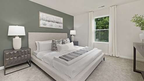 Carpeted primary bedroom with small window