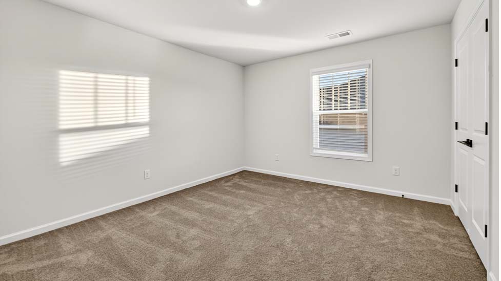 Carpeted bedroom with large window