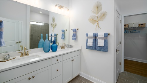 Primary bathroom with double sinks, white cabinets