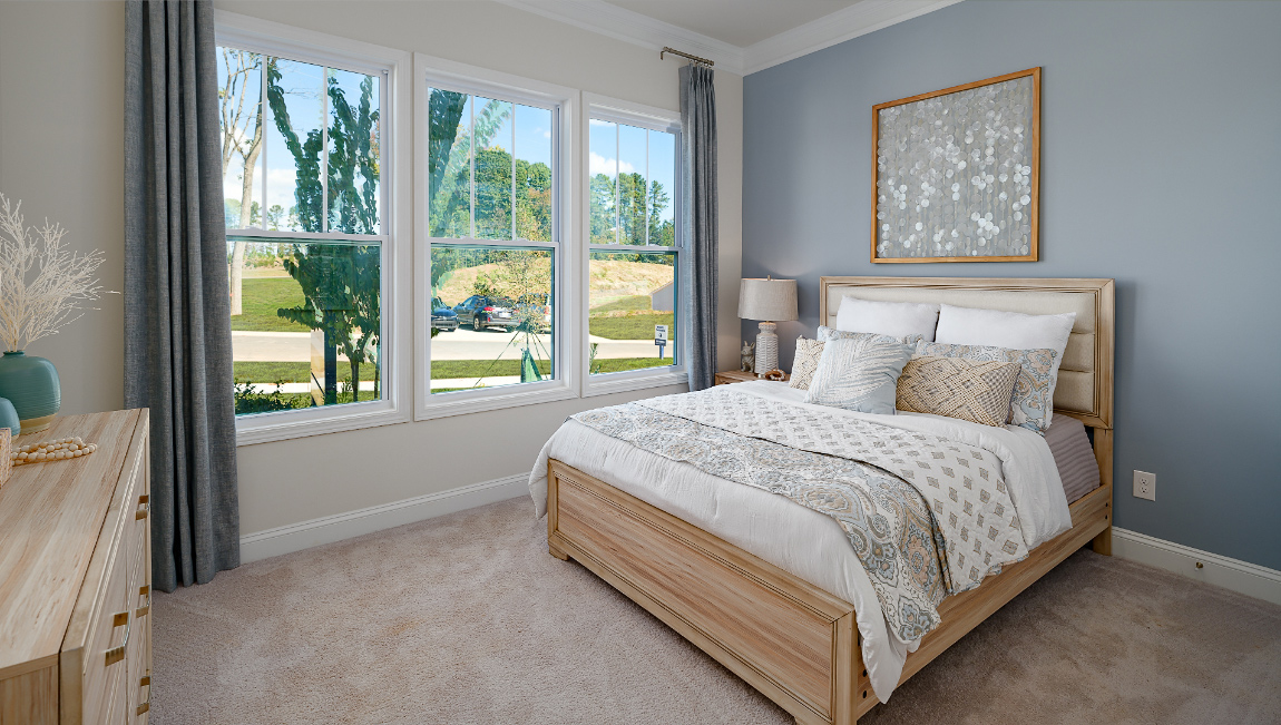Carpeted bedroom three large windows