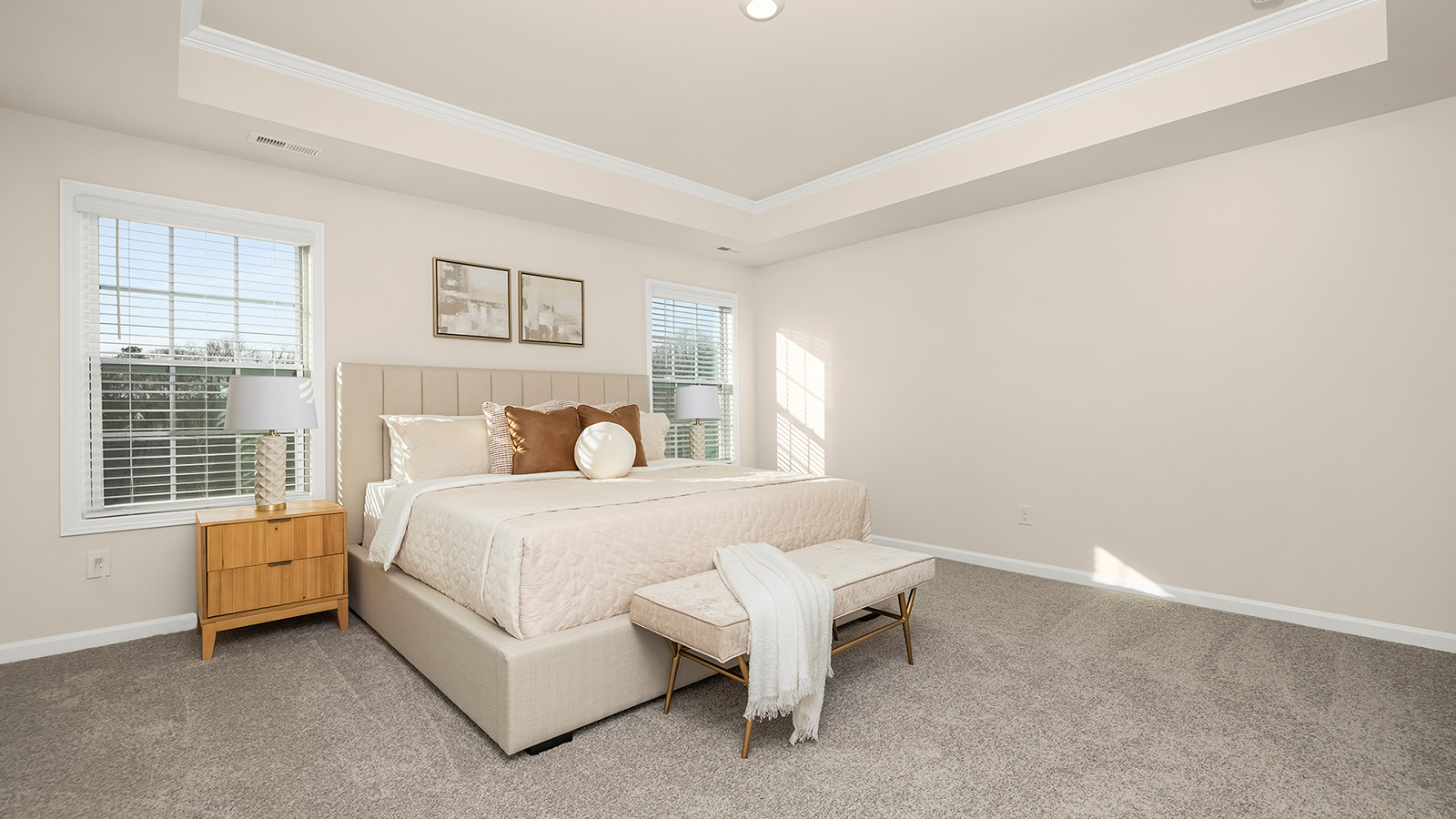 primary carpeted bedroom with two large windows