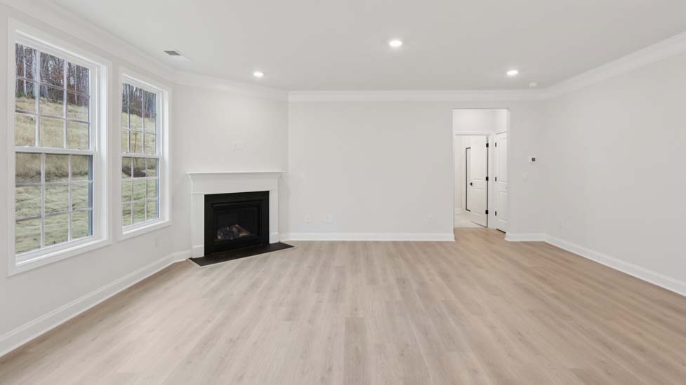 Open concept family room with fireplace and large windows