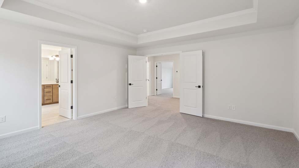 Primary carpeted bedroom with windows