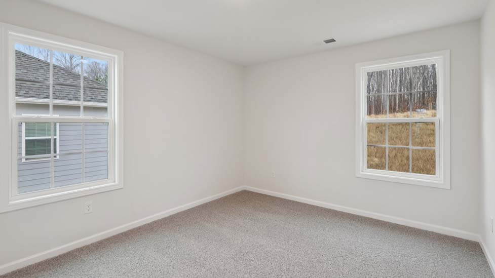 Carpeted bedroom with windows