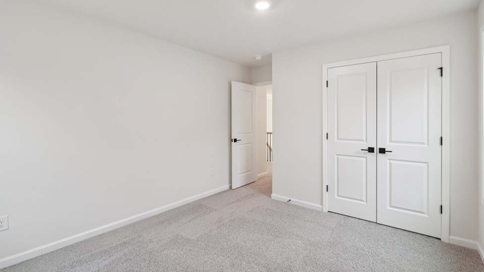 Carpeted bedroom with windows