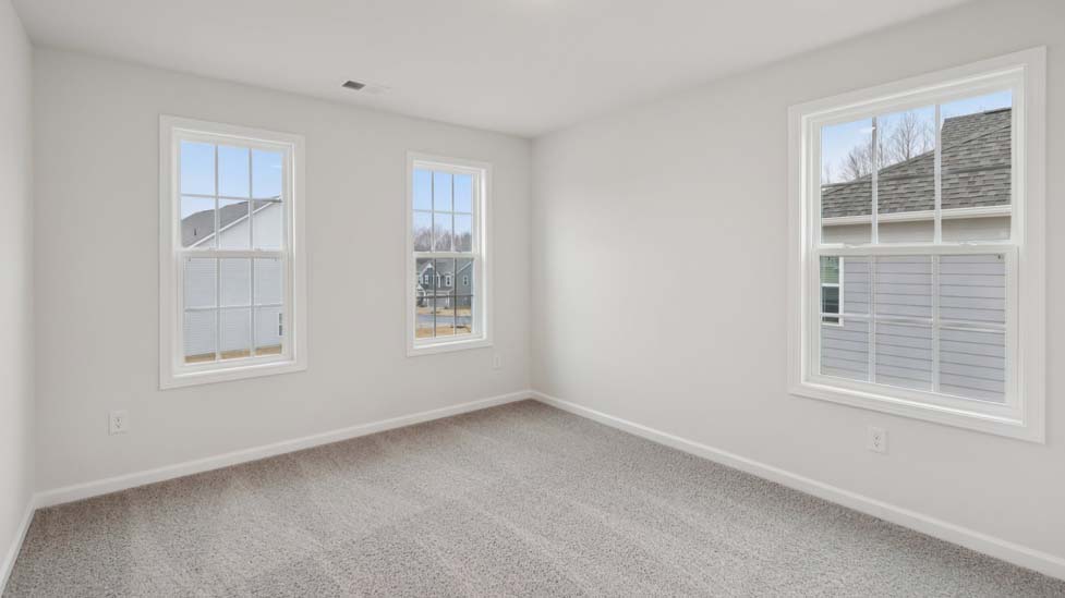 Carpeted bedroom with windows