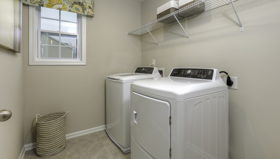 Laundry room with built in racks above machines