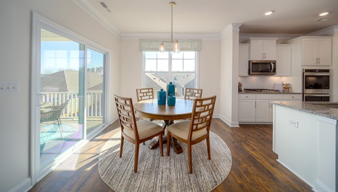 Eating area beside kitchen, wood floors, and sliding glass back door