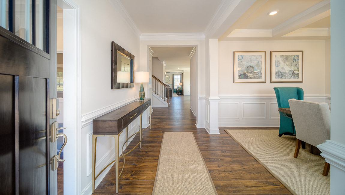 Welcoming foyer with wood floors, and view of entrance hallway