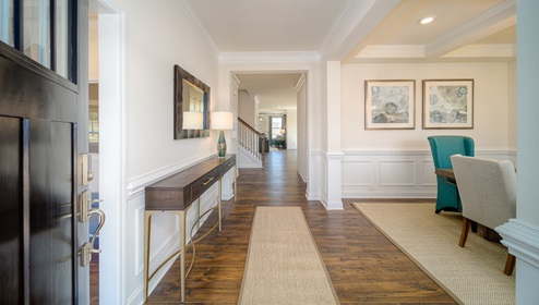 Welcoming foyer with wood floors, and view of entrance hallway