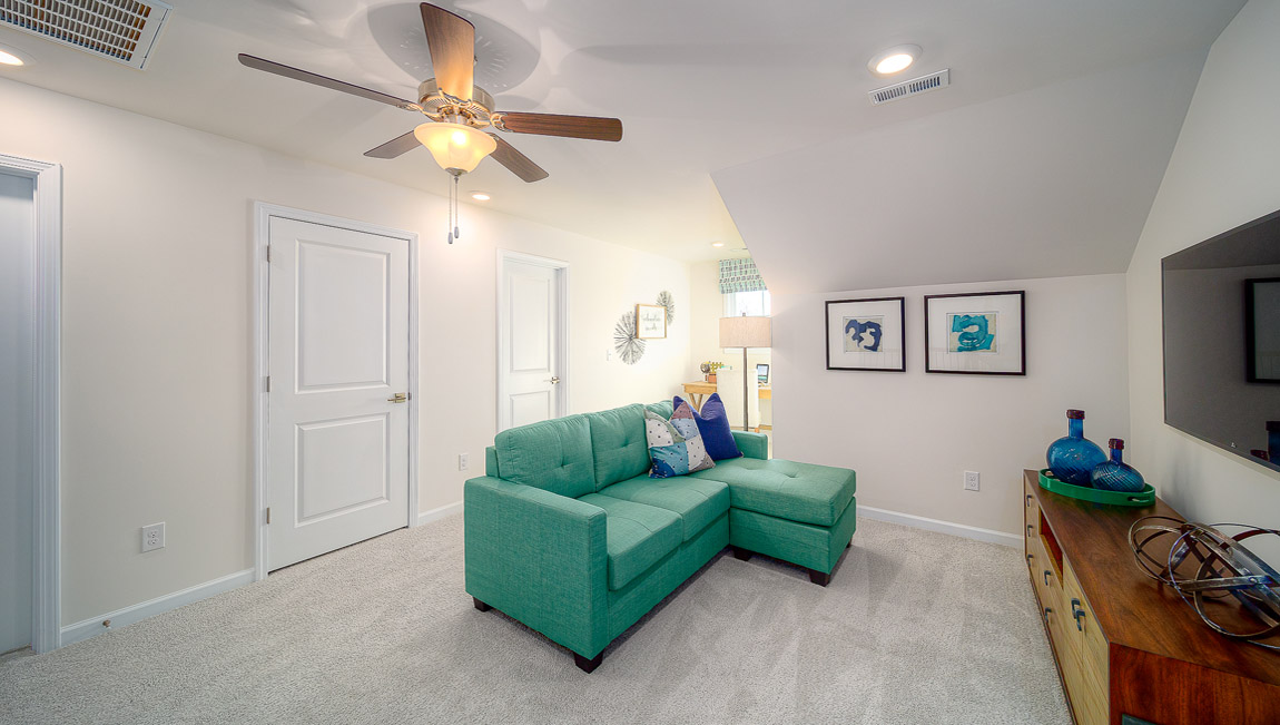 Upstairs carpeted loft space with small window