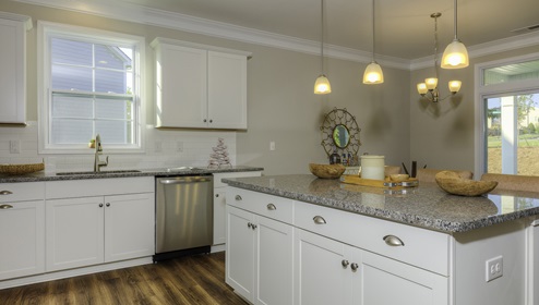 Kitchen with white cabinets, white subway tile backsplash, and stainless steel appliances