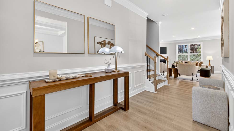 Welcoming foyer with staircase view and wood floors