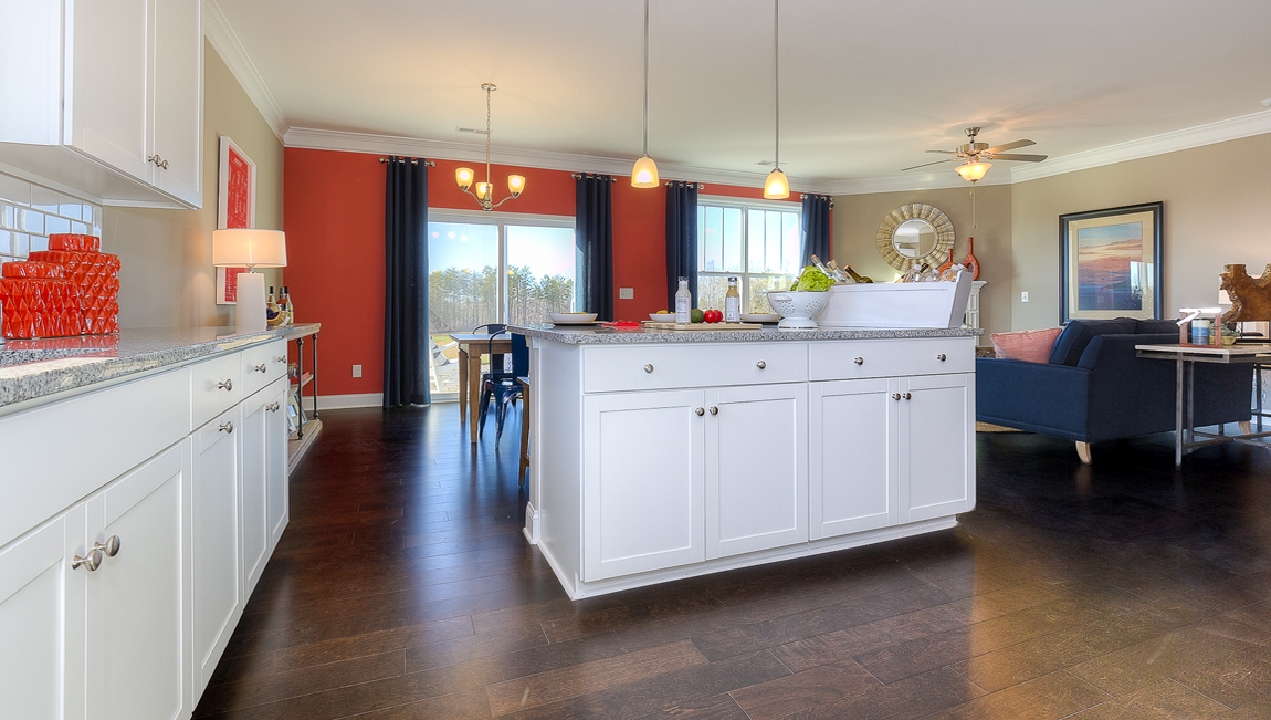 Kitchen and island with white cabinets, breakfast area at island bar, and stainless steel appliances