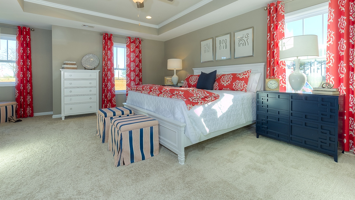 Primary bedroom with carpet and large windows