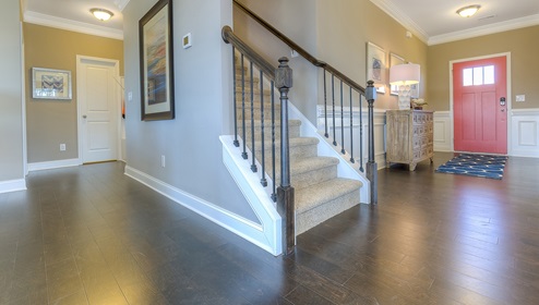 Welcoming foyer with staircase view and wood floors