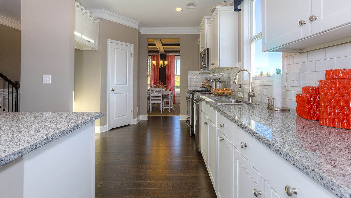 Kitchen and island with white cabinets, breakfast area at island bar, and stainless steel appliances