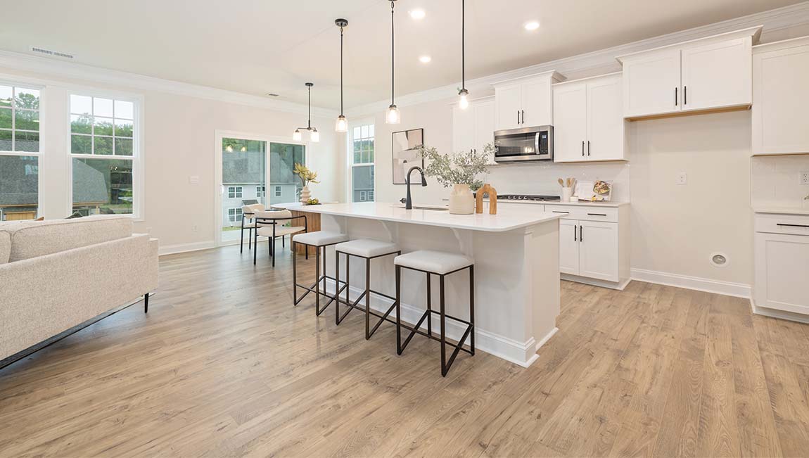 open concept kitchen and island with white cabinets and stainless steel appliances