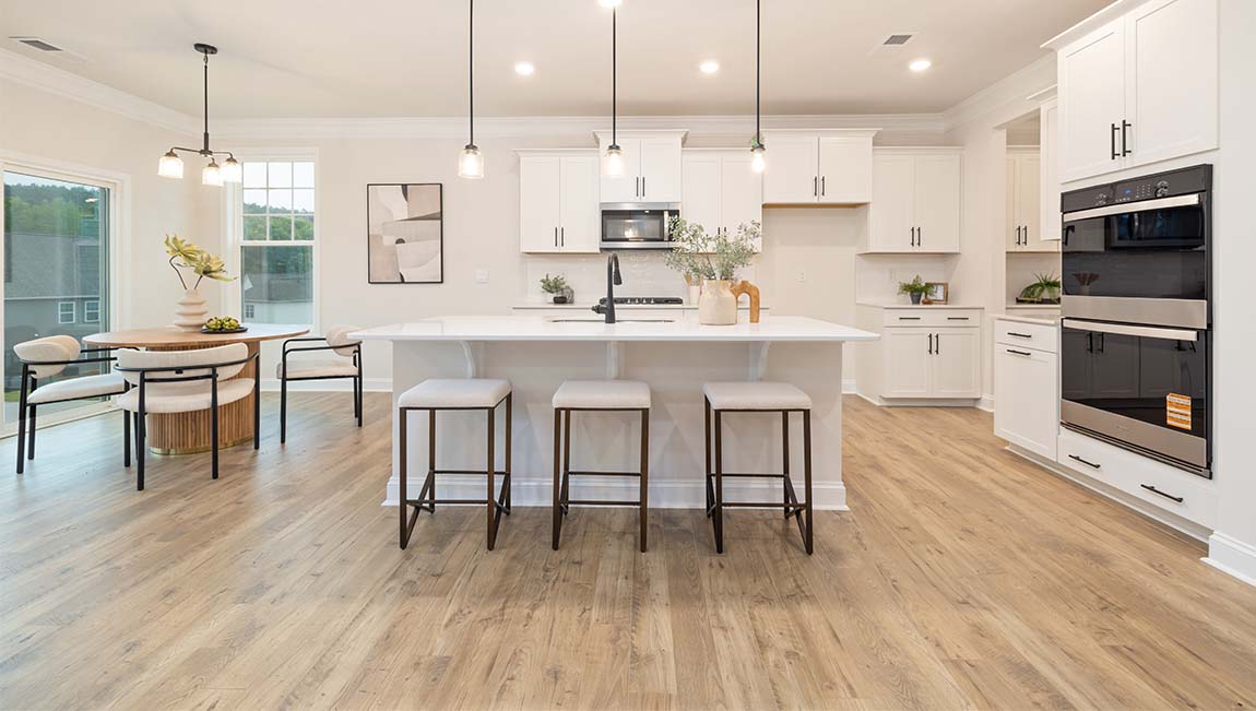 open concept kitchen and island with white cabinets and stainless steel appliances