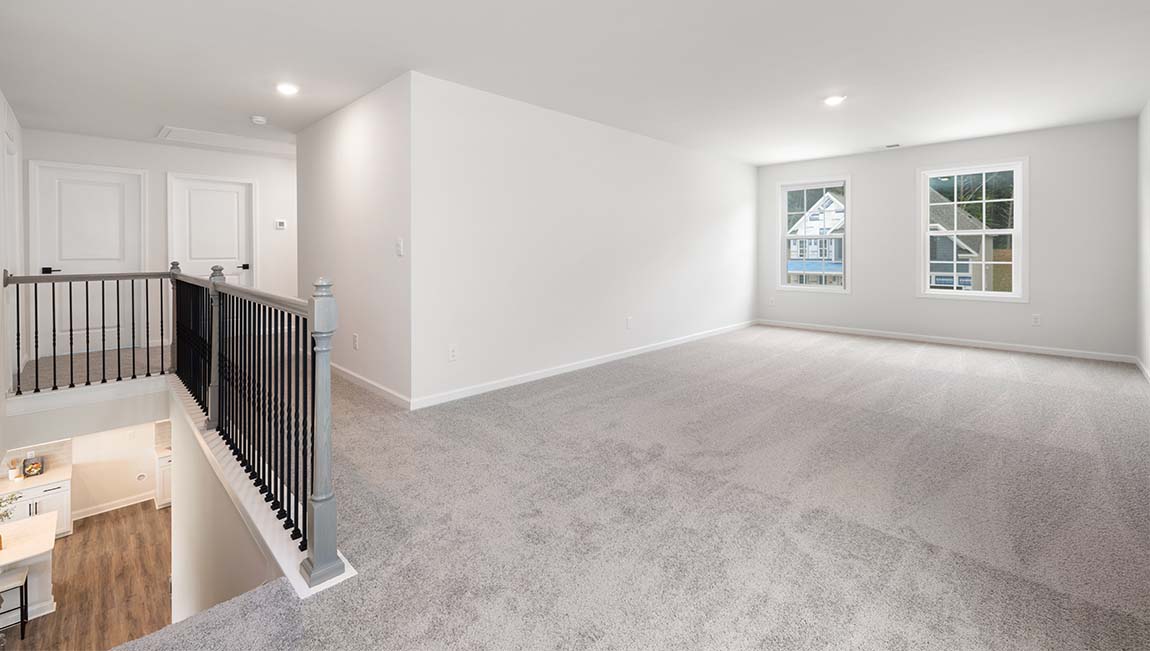 Carpeted upstairs loft with large windows