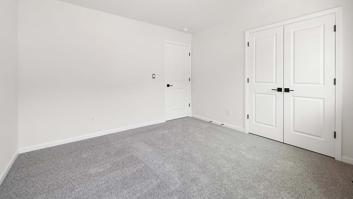 Carpeted upstairs loft with large windows