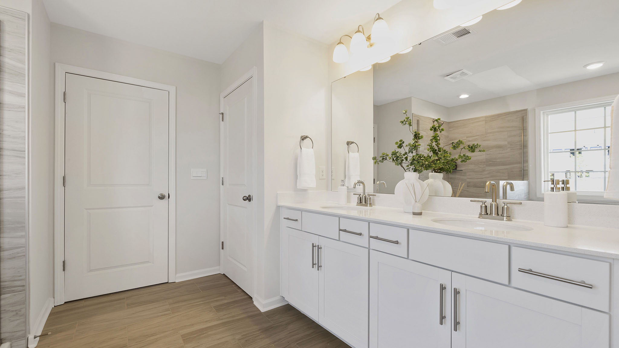 Primary bathroom with large window, bath, and standing shower