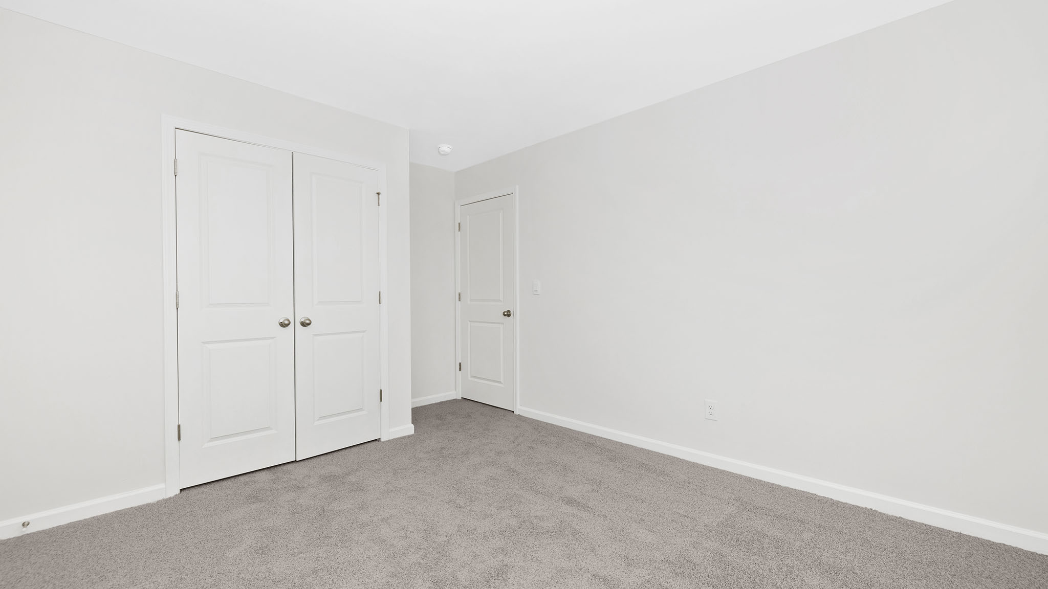 Carpeted bedroom with small window