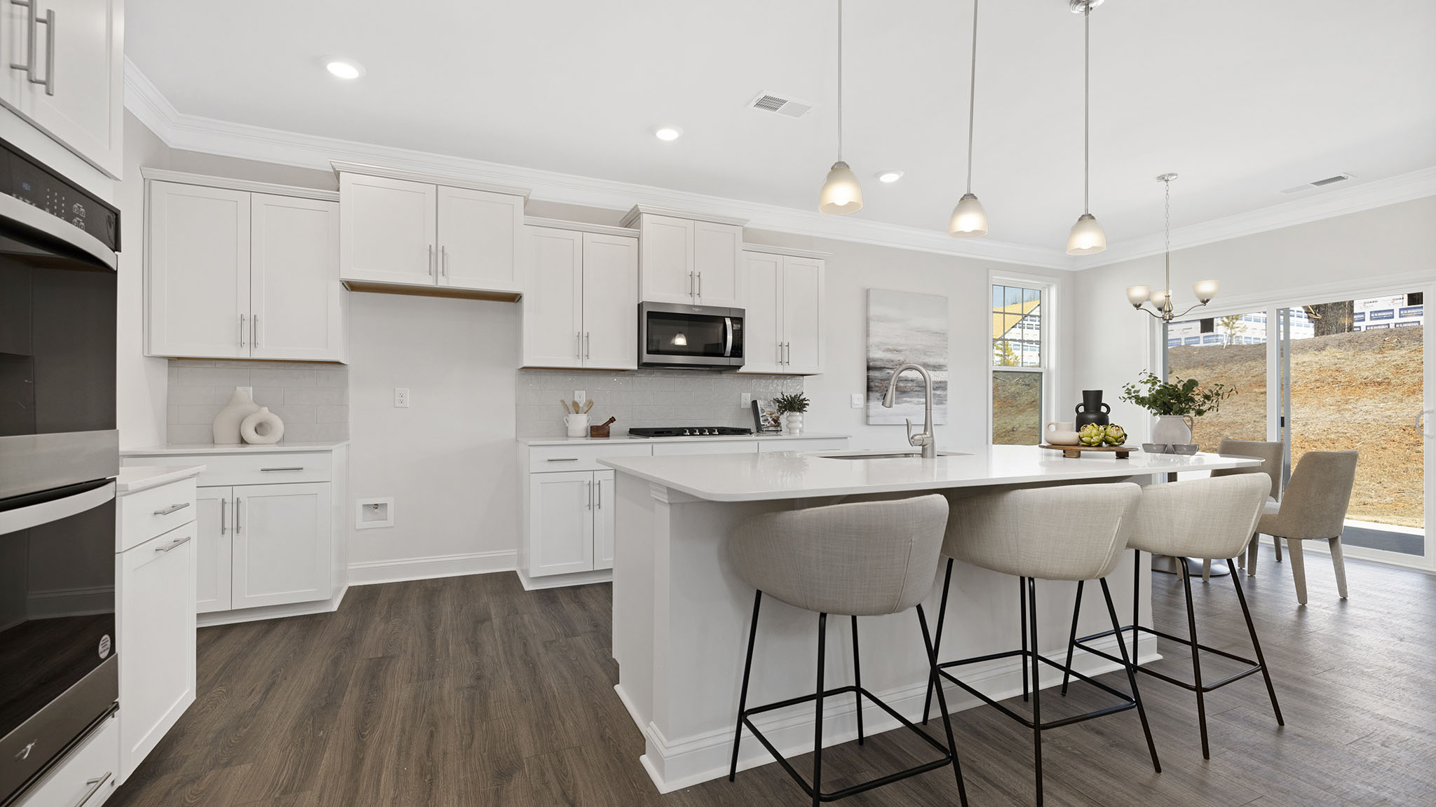 open concept kitchen and island with white cabinets and stainless steel appliances