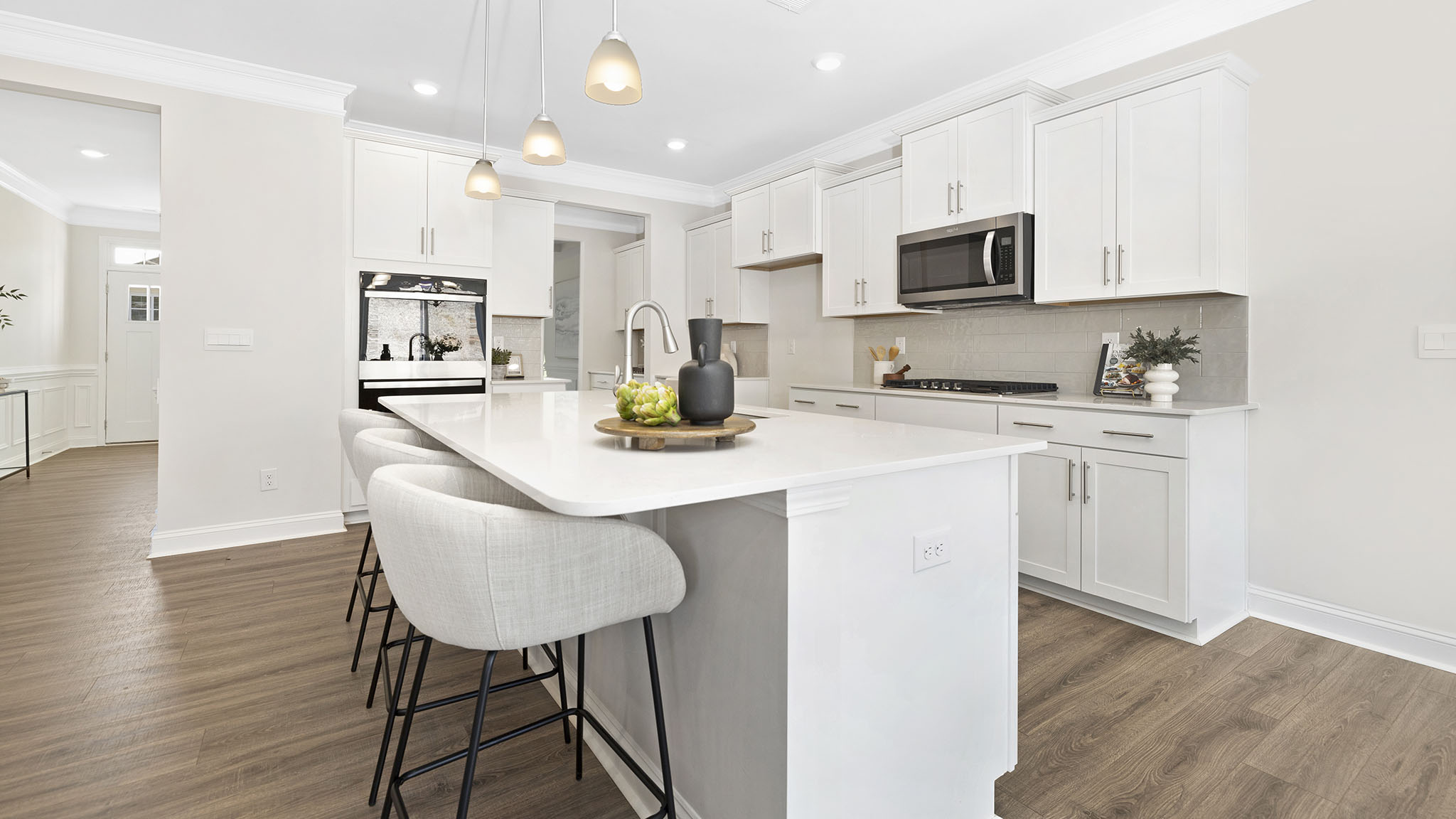 open concept kitchen and island with white cabinets and stainless steel appliances