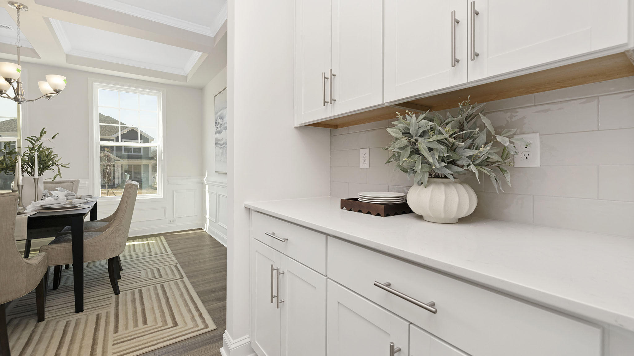 open concept kitchen and island with white cabinets and stainless steel appliances